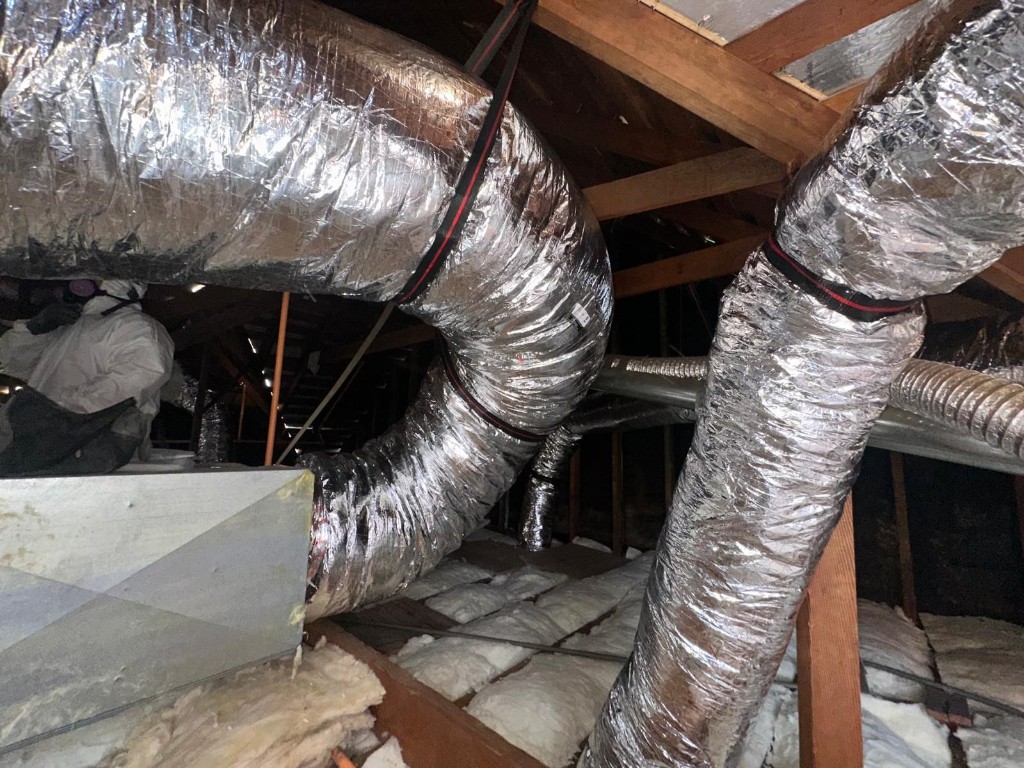 Attic with new fiberglass batt insulation installed to target R-value