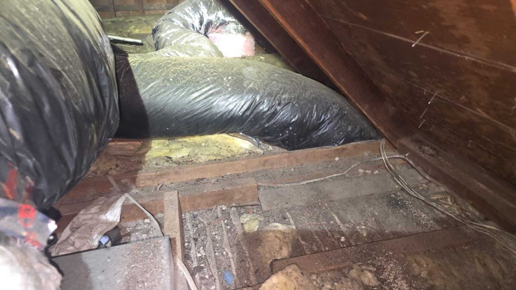 Pure Eco crew vacuuming and bagging old attic insulation in protective gear