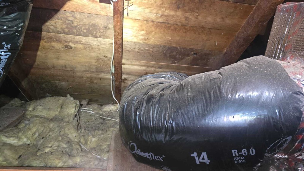 Pure Eco crew vacuuming and bagging old attic insulation in protective gear