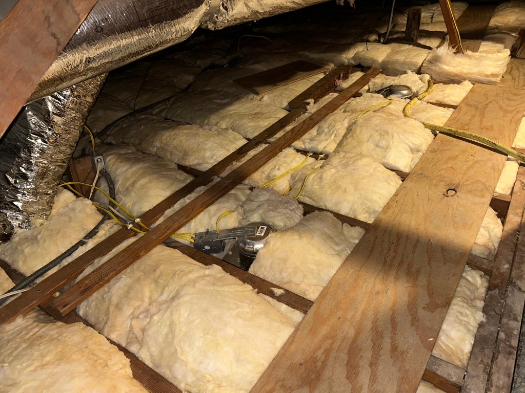 Attic with new fiberglass batt insulation installed to target R-value