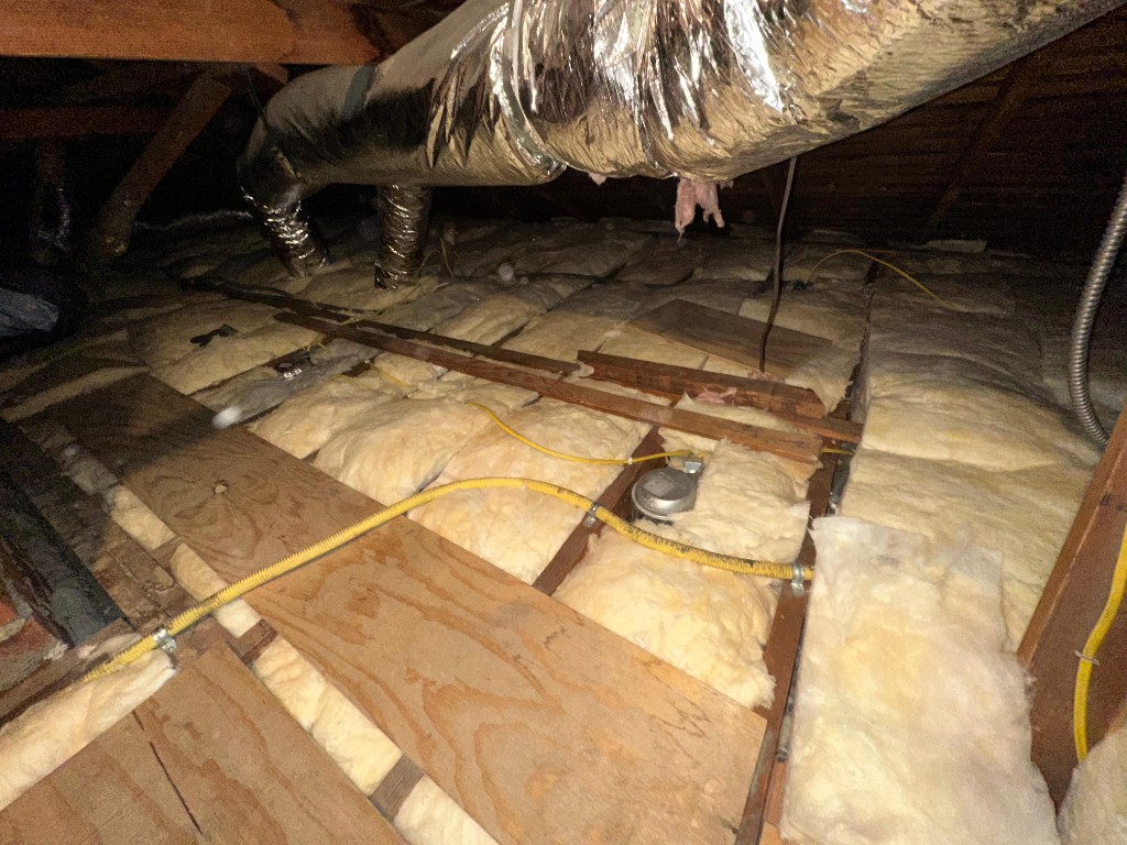 Attic with new fiberglass batt insulation installed to target R-value
