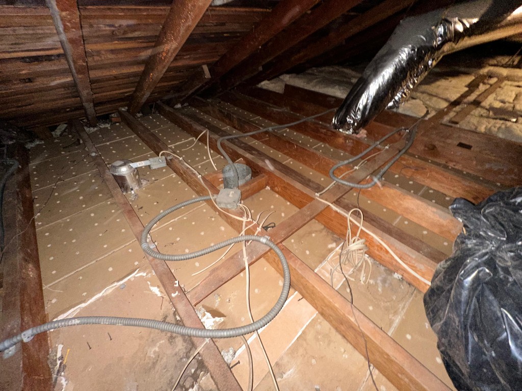 Pure Eco installer placing new fiberglass batts between attic joists