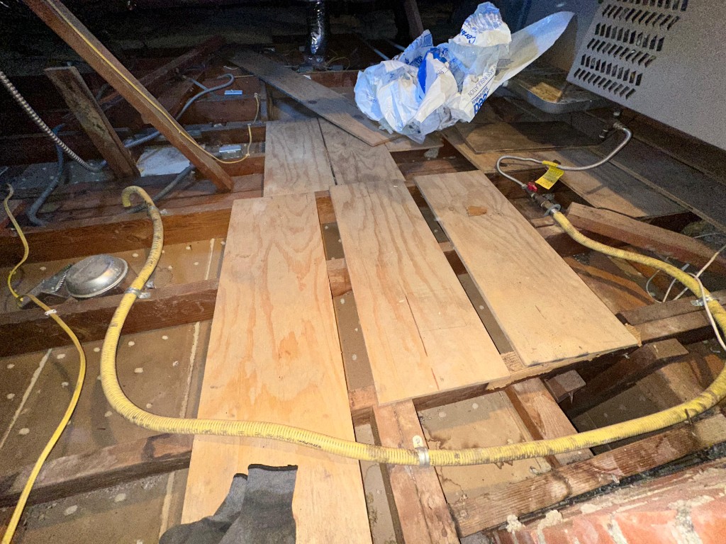 Pure Eco installer placing new fiberglass batts between attic joists