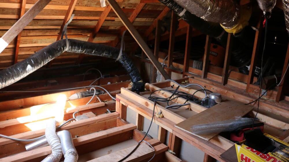 Pure Eco crew vacuuming and bagging old attic insulation in protective gear