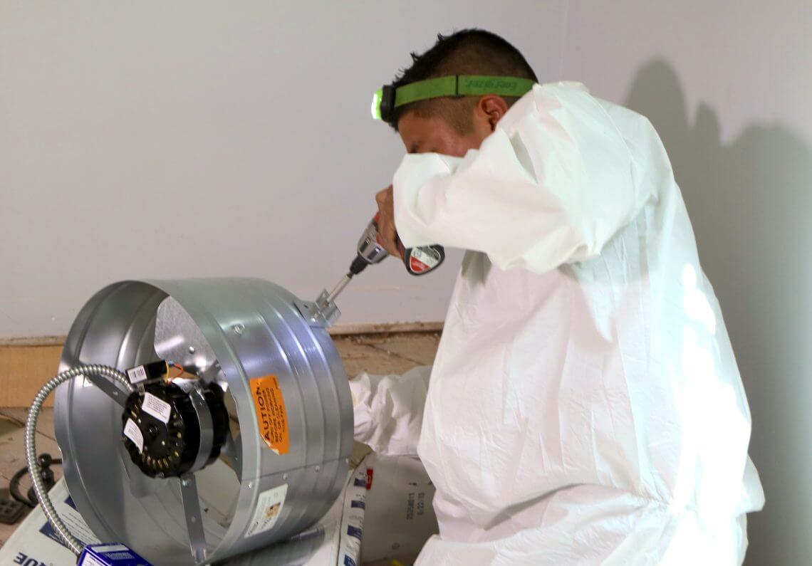 Pure Eco technician installing a powered attic ventilation fan