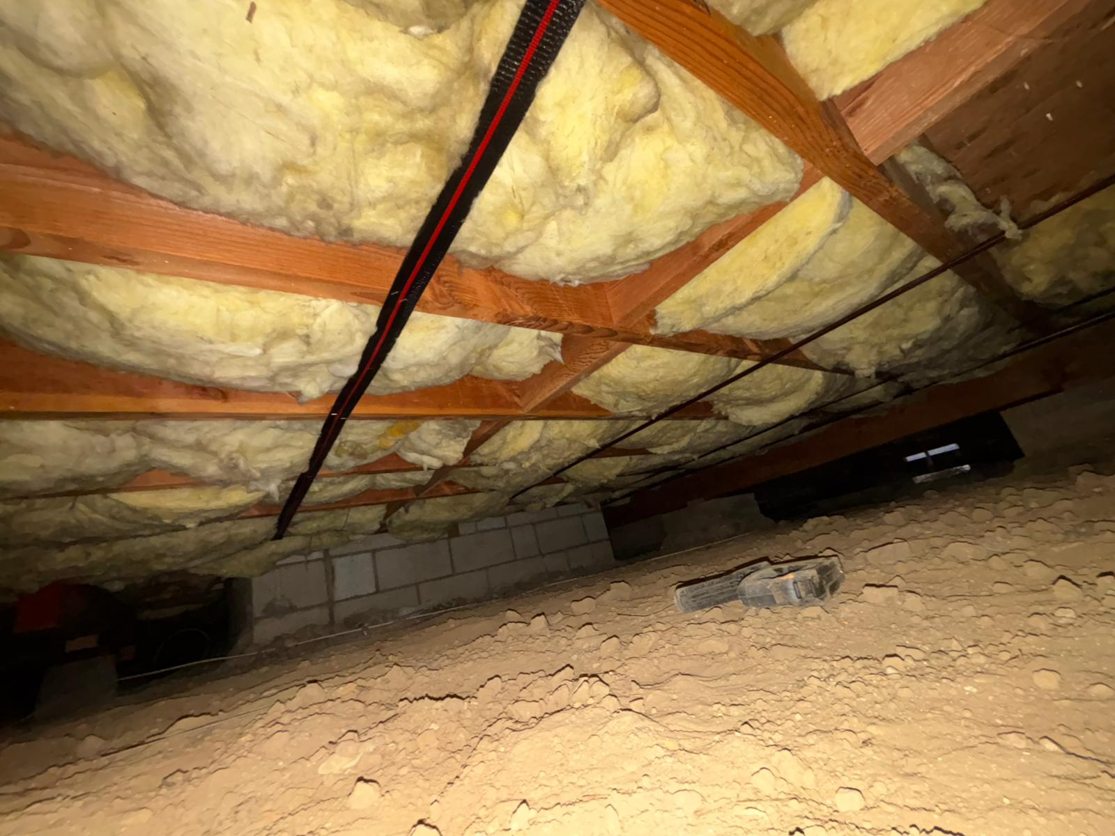 New crawlspace batt insulation secured between floor joists
