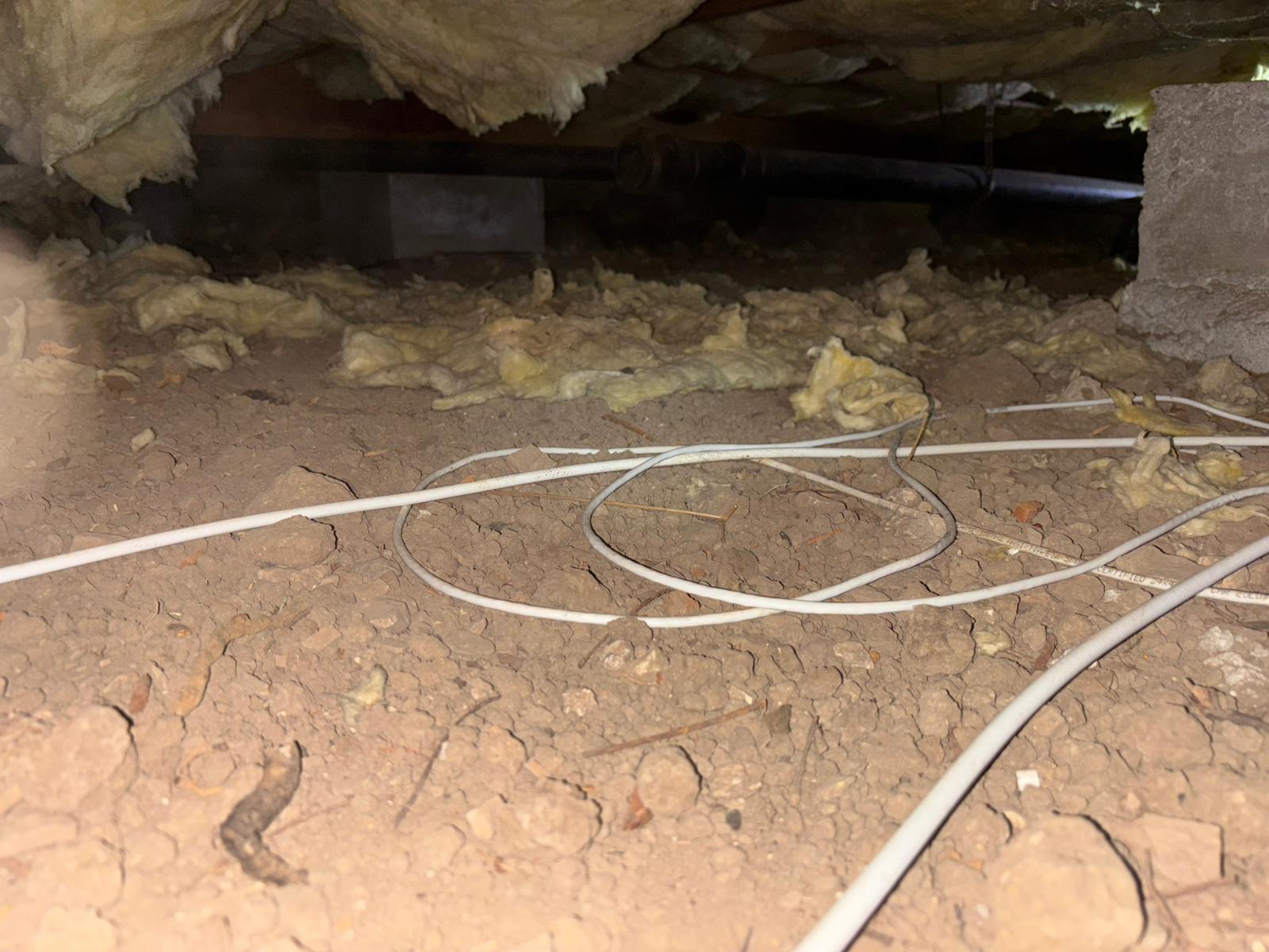 Crawlspace with failed underfloor insulation before replacement