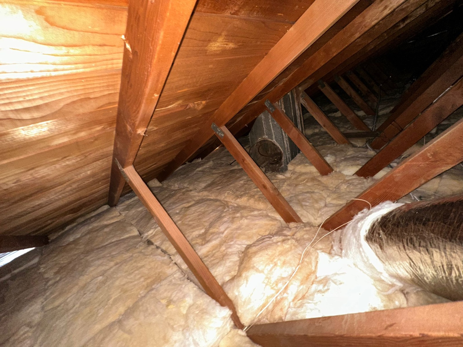 Attic with new fiberglass batt insulation installed to target R-value