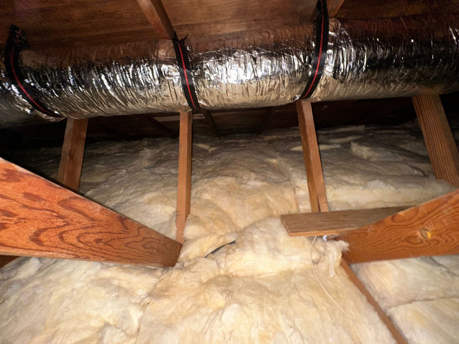 Attic with new fiberglass batt insulation installed to target R-value