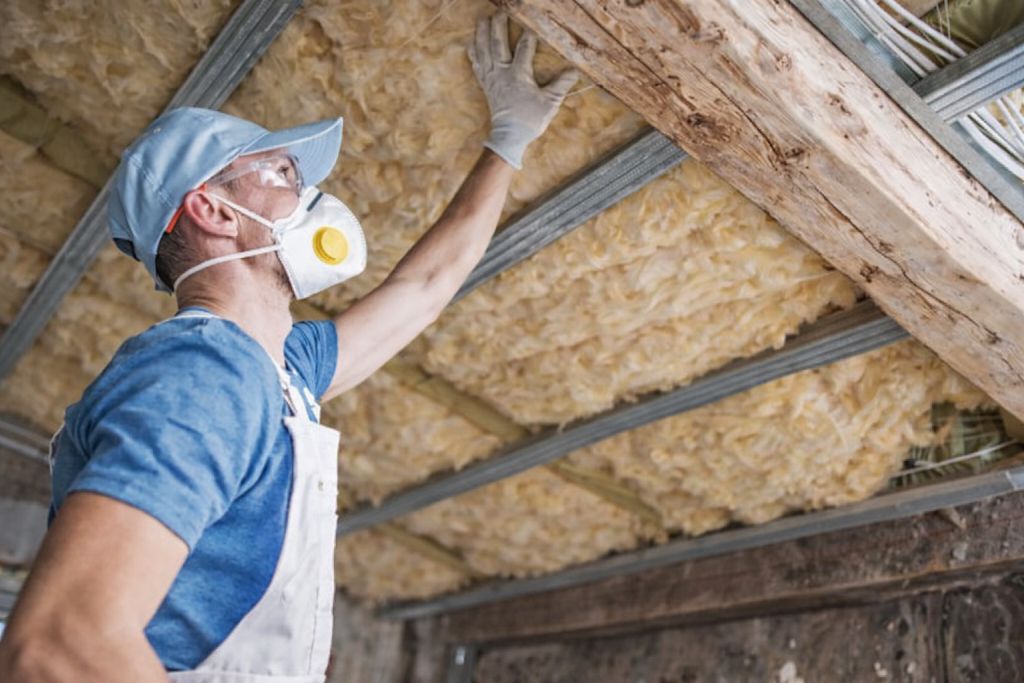 Technician installing attic insulation in a Santa Clarita home to improve energy efficiency and indoor comfort