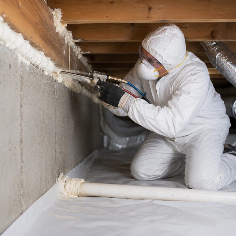Professional air sealing technician applying spray foam sealant inside a crawl space in Chatsworth, CA.