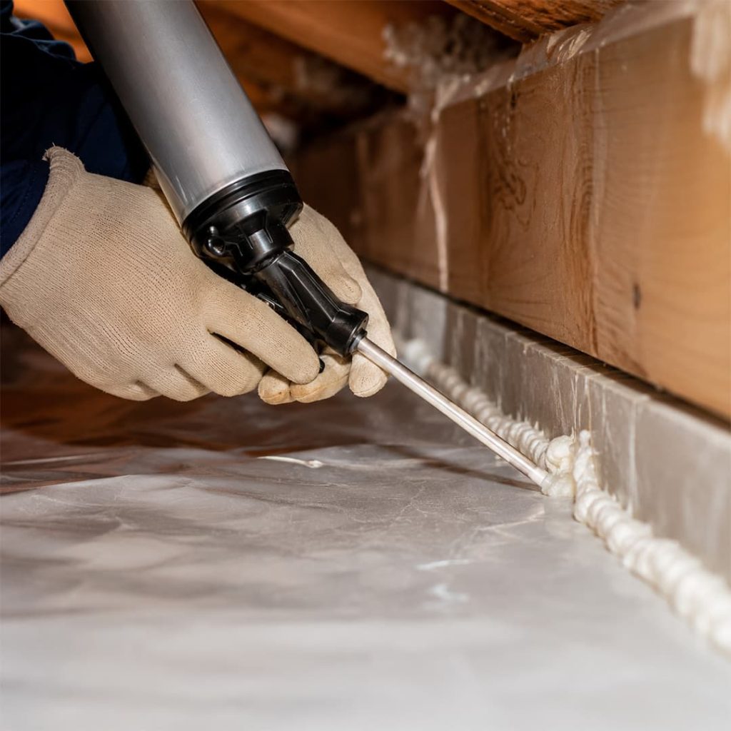 Close-up of air sealing work with foam sealant being applied along crawl space gaps in Northridge, CA.