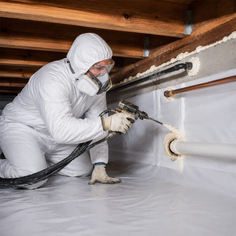 Professional technician applying foam sealant around crawl space pipes for air sealing in Northridge, CA.