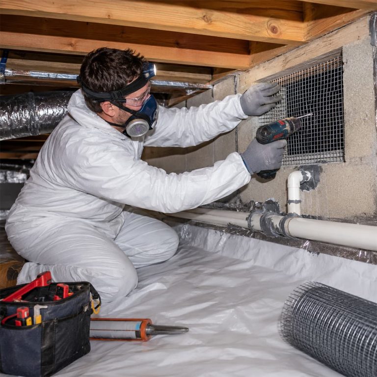 Professional rat proofing technician installing wire mesh over a crawl space vent in Chatsworth, CA.