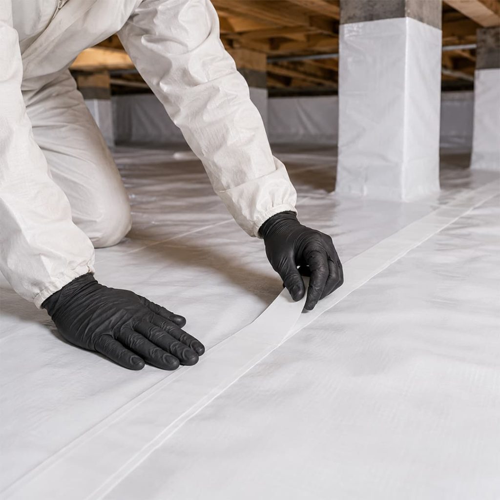 Close-up of a technician sealing seams on a white crawl space vapor barrier in Chatsworth, CA.