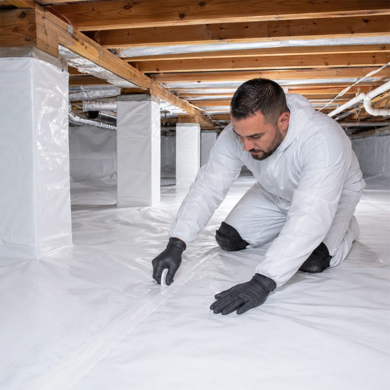 Professional technician installing a white crawl space vapor barrier in Chatsworth, CA.