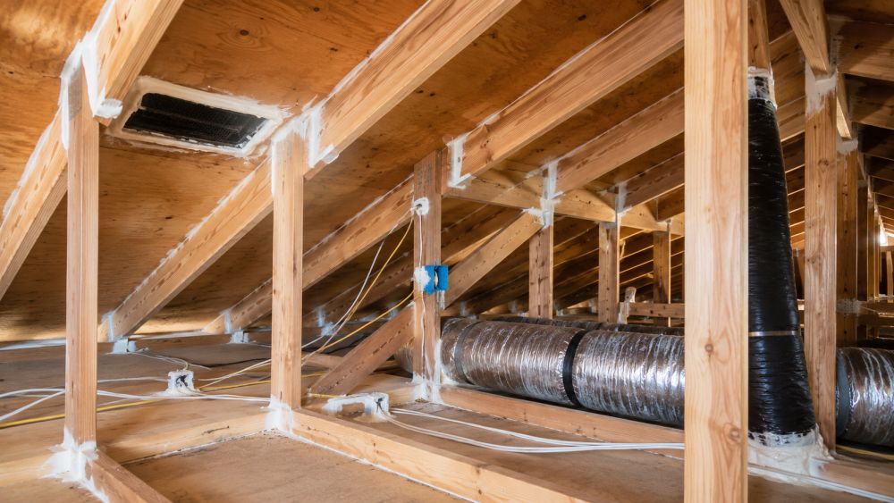 A residential attic in Sherman Oaks, California showing professional air sealing work around exposed wooden framing, roof decking, and attic penetrations. Gaps around utility lines, electrical openings, and structural joints have been sealed to reduce unwanted airflow and energy loss. Pure Eco provides Air Sealing in Sherman Oaks, CA to help homeowners improve comfort, indoor air quality, and energy efficiency. The image highlights a clean attic environment with visible air sealing materials applied throughout key leakage areas. Homeowners can contact Pure Eco at (877) 870-7998 for attic inspections, air sealing services, insulation upgrades, and energy-saving improvements throughout Sherman Oaks and the Greater Los Angeles area.